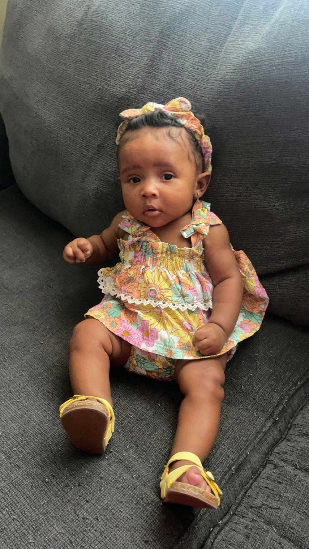 Dyomni is registered to the contest to win money with this photo: baby, child, girl, sitting, couch, dress, floral, headband, footwear, sandals, indoors, curious, cute, person, portrait, infant, comfortable, colorful, young, fashion