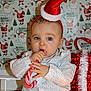 baby, child, candy_cane, christmas_hat, holiday_lights, gift_box, festive, santa, wrapping_paper, polka_dot_shirt, cute, indoors, celebration, holiday, smiling, sitting, decorations, red, white, toddler