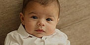 Lukyan a rejoint le concours — aidez-le/la à gagner de superbes lots ! baby, infant, child, face, eyes, white_shirt, collar, sofa, couch, beige_background, indoor, portrait, closeup, looking_at_camera, cute, newborn, hair, skin_tone, sitting, calm