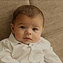 baby, infant, child, face, eyes, white_shirt, collar, sofa, couch, beige_background, indoor, portrait, closeup, looking_at_camera, cute, newborn, hair, skin_tone, sitting, calm
