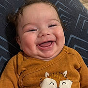 Kaïs Miguel participe au concours pour gagner de l'argent avec cette photo : baby, smiling, laughing, infant, clothing, onesie, fox, text, brown, cute, happy, face, hair, cushion, pattern, indoors, child, portrait, toddler, cozy