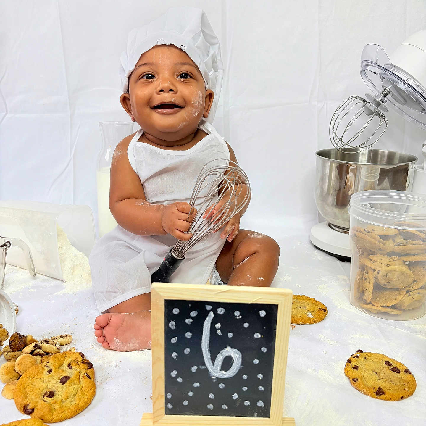 Immanuel joined the competition — help win amazing prizes! apron, baby, baking, chef_hat, child, container, cookies, cute, flour, food, happy, indoor, kitchen_appliance, milk, playful, portrait, sitting, smiling, whisk, young_child