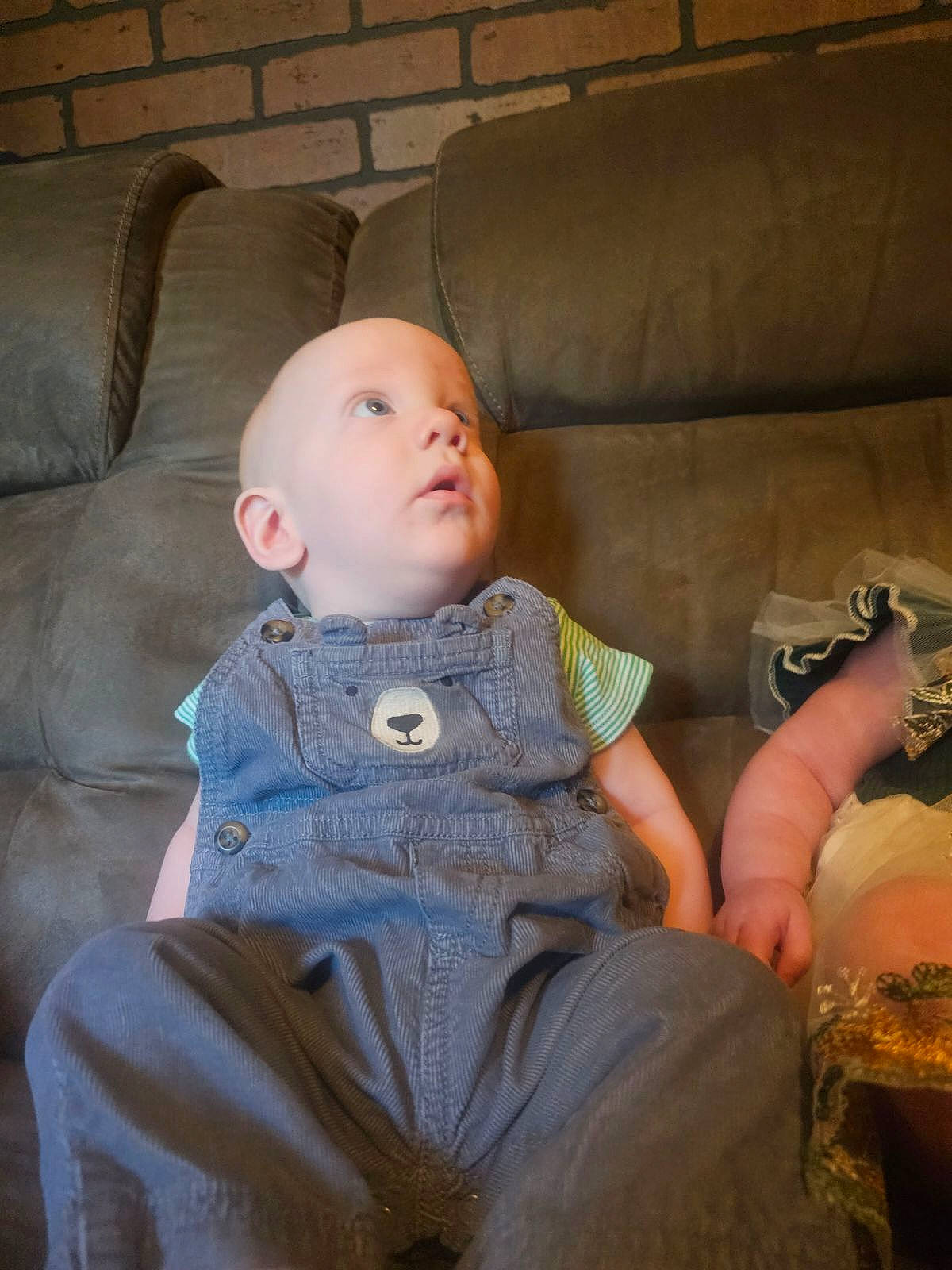 Daryl is registered to the contest to win money with this photo: baby, baby_toddler_clothing, cheek, child, comfort, couch, dress, fur, living_room, mammal, person, room, sitting, skin, sleeve, textile, toddler, wood