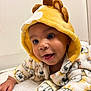 Noah Jeuniel is registered to the contest to win money with this photo: apparel, baby, background, child, clothing, cute, eyes, face, hand, happy, hood, indoor, infant, lion, lying, plush, smile, soft, toddler, white