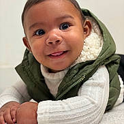 Noah Jeuniel joined the competition — help win amazing prizes! baby, child, face, smile, tongue, eyes, vest, green, white_sweater, hand, crawling, indoor, cute, portrait, infant, warm_clothing, fluffy_surface, closeup, happy, skin