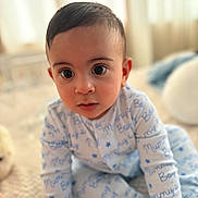 Kairo joined the competition — help win amazing prizes! baby, child, pajamas, blue_text, mummy's_boy, sitting, bed, blanket, indoors, curious_eyes, face, person, cute, soft_light, close_up, young_child, infant, portrait, cozy, expression