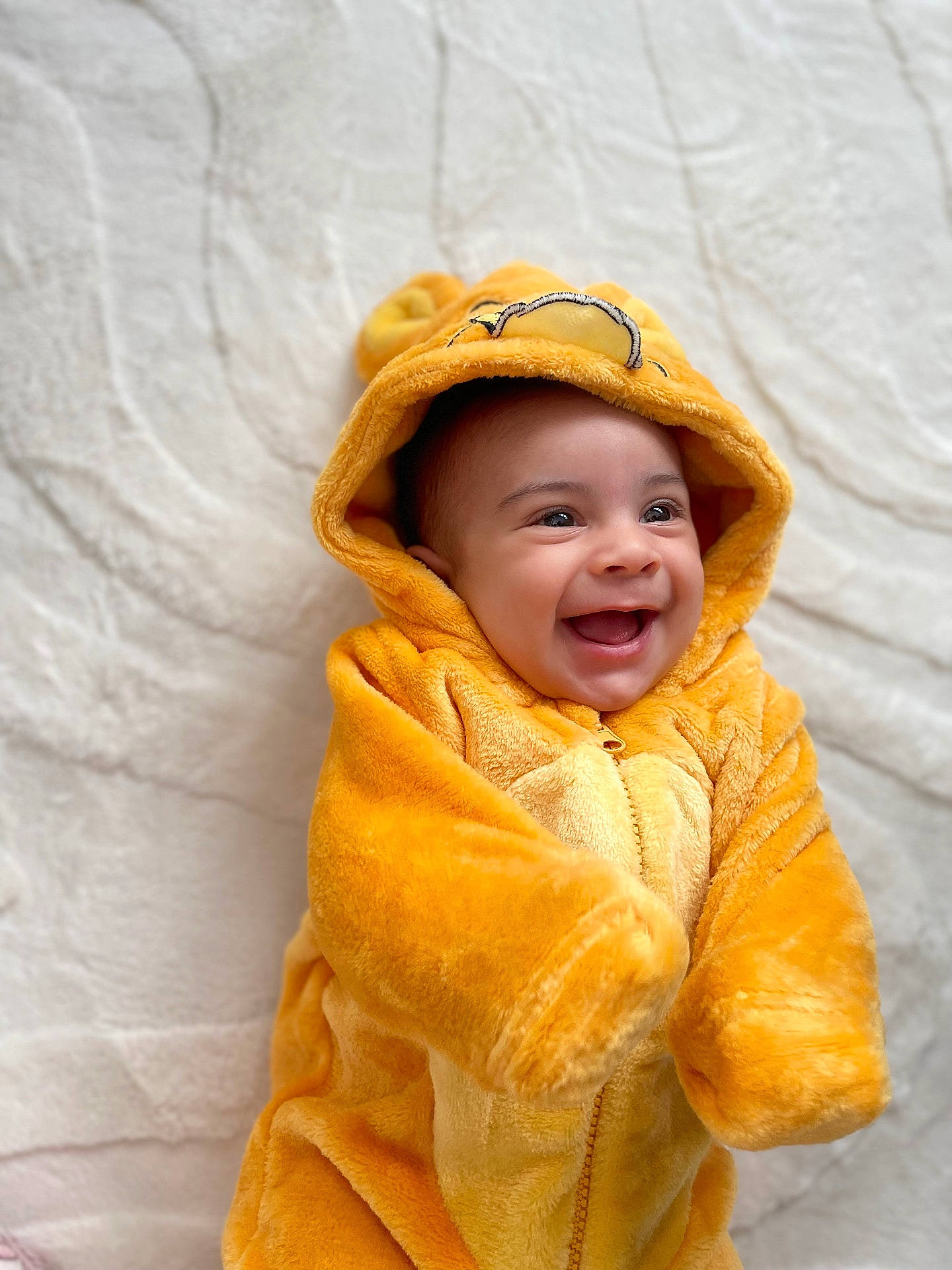 baby, babylaughing, blanket, clothing, coat, face, happy, hat, head, hood, hoodie, jacket, knitwear, laughing, person, photography, portrait, smile, sweater, towel