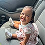 Emely is registered to the contest to win money with this photo: toddler, child, smiling, car_seat, dress, white_shoes, happy, indoor, portrait, baby, cute, person, seat, car_interior, sitting, young_child, clothing, footwear, head, face