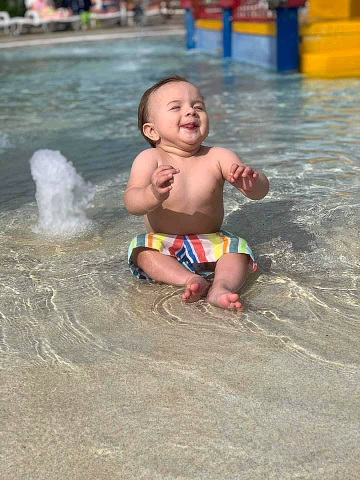 Trevon is registered to the contest to win money with this photo: barechested, barefoot, bathing, body_of_water, chest, child, fun, happy, leisure, nonbuilding_structure, people_on_beach, person, play, recreation, sand, smile, swimming_pool, thigh, toddler, trunk