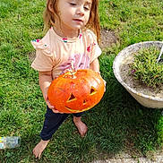 Sonaly participe au concours pour gagner de l'argent avec cette photo : autumn, barefoot, carved_pumpkin, child, clothing, cute, daylight, face, garden, grass, holiday, jack_o_lantern, nature, outdoor, person, plant_pot, pumpkin, smiling, toddler, toy