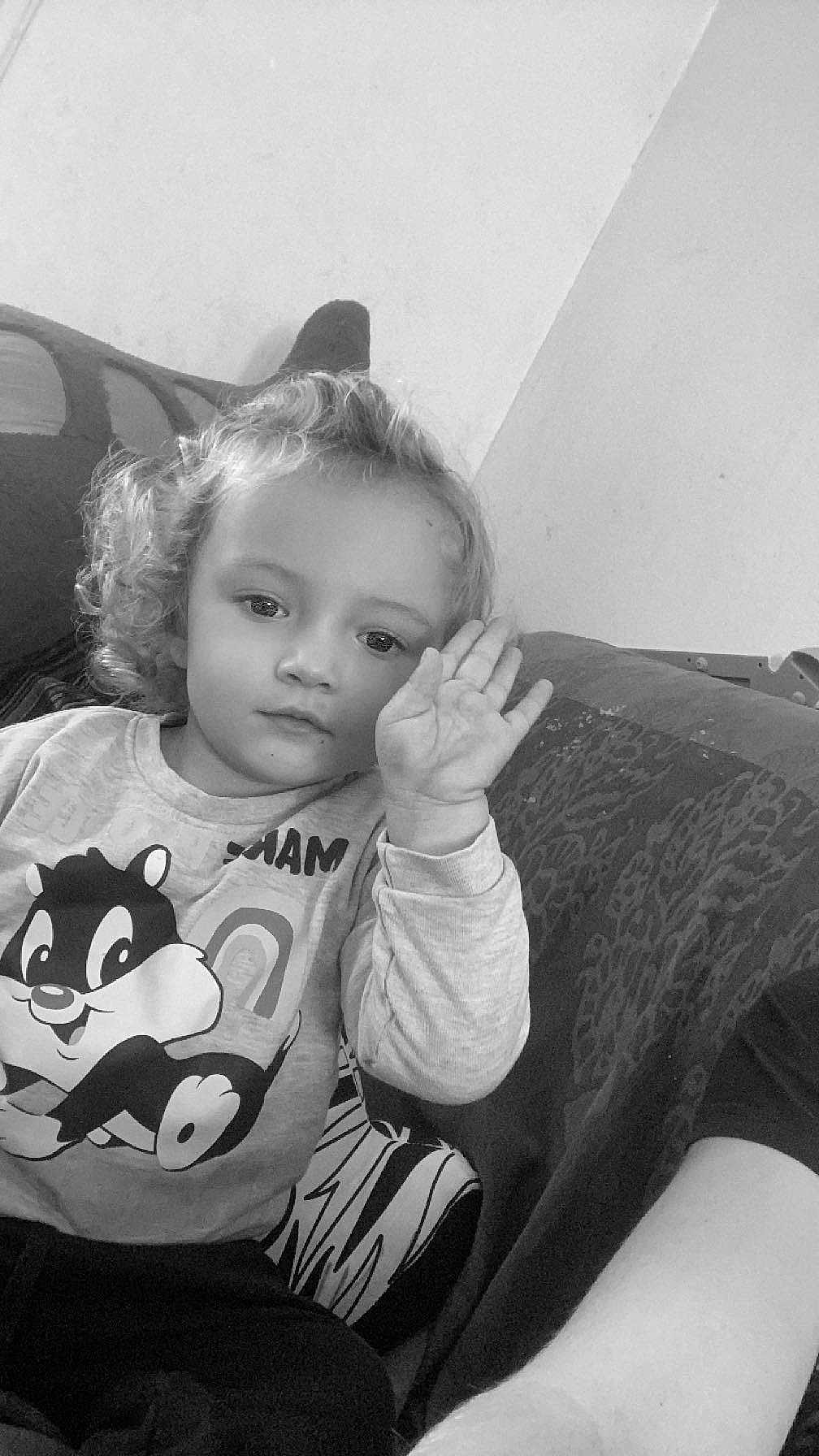 Solyna a rejoint le concours — aidez-le/la à gagner de superbes lots ! black_and_white, cartoon_shirt, casual_clothing, child, couch, curly_hair, cute, expression, face, hand, home, indoor, patterned_fabric, person, portrait, raising_hand, relaxed, sitting, young, young_child
