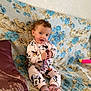 Solyna a rejoint le concours — aidez-le/la à gagner de superbes lots ! toddler, child, pajamas, minnie_mouse, phone, curly_hair, couch, floral_pattern, pink_socks, striped_socks, indoor, smiling, seated, cute, playful, young_child, fabric, pillow, home_interior, person
