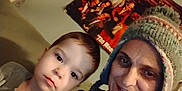 Brayden is registered to the contest to win money with this photo: child, adult, person, hat, knit_hat, couch, indoor, wall, poster, smile, face, portrait, casual_clothing, seated, cozy, home, curious, warm, together, selfie