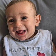Tiago a rejoint le concours — aidez-le/la à gagner de superbes lots ! baby, bib, celebration, close_up, clothing, cute, day, eyes, face, happy, heart, indoors, infant, mother, mouth_open, portrait, skin, smiling, soft_background, textile