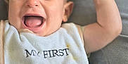 Tiago participe au concours pour gagner de l'argent avec cette photo : arm, baby, bib, child, clothing, cute, expression, face, footprints, happy, human, infant, laughing, lying_down, mouth_open, portrait, skin, smile, soft_surface, young