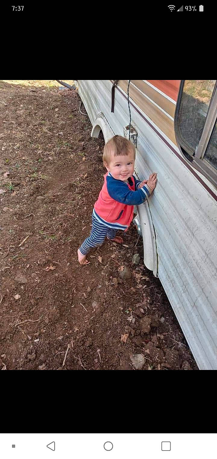 Eli is registered to the contest to win money with this photo: asphalt, baby, baby_toddler_clothing, child, city, flooring, grass, joy, leisure, outdoor_play_equipment, people_in_nature, person, recreation, road_surface, soil, swing, t_shirt, tints_and_shades, toddler, tree