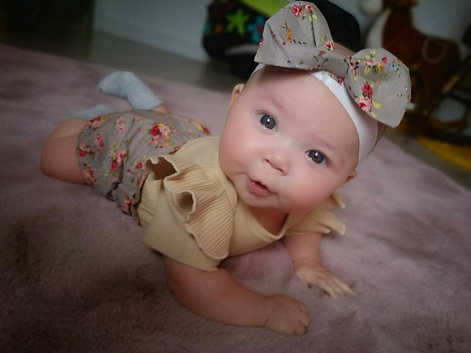 Lou a rejoint le concours — aidez-le/la à gagner de superbes lots ! baby, baby_toddler_clothing, cap, cheek, child, costume_hat, ear, eyebrow, fashion_accessory, fawn, flooring, happy, headgear, headpiece, headwear, iris, person, pink, skin, textile