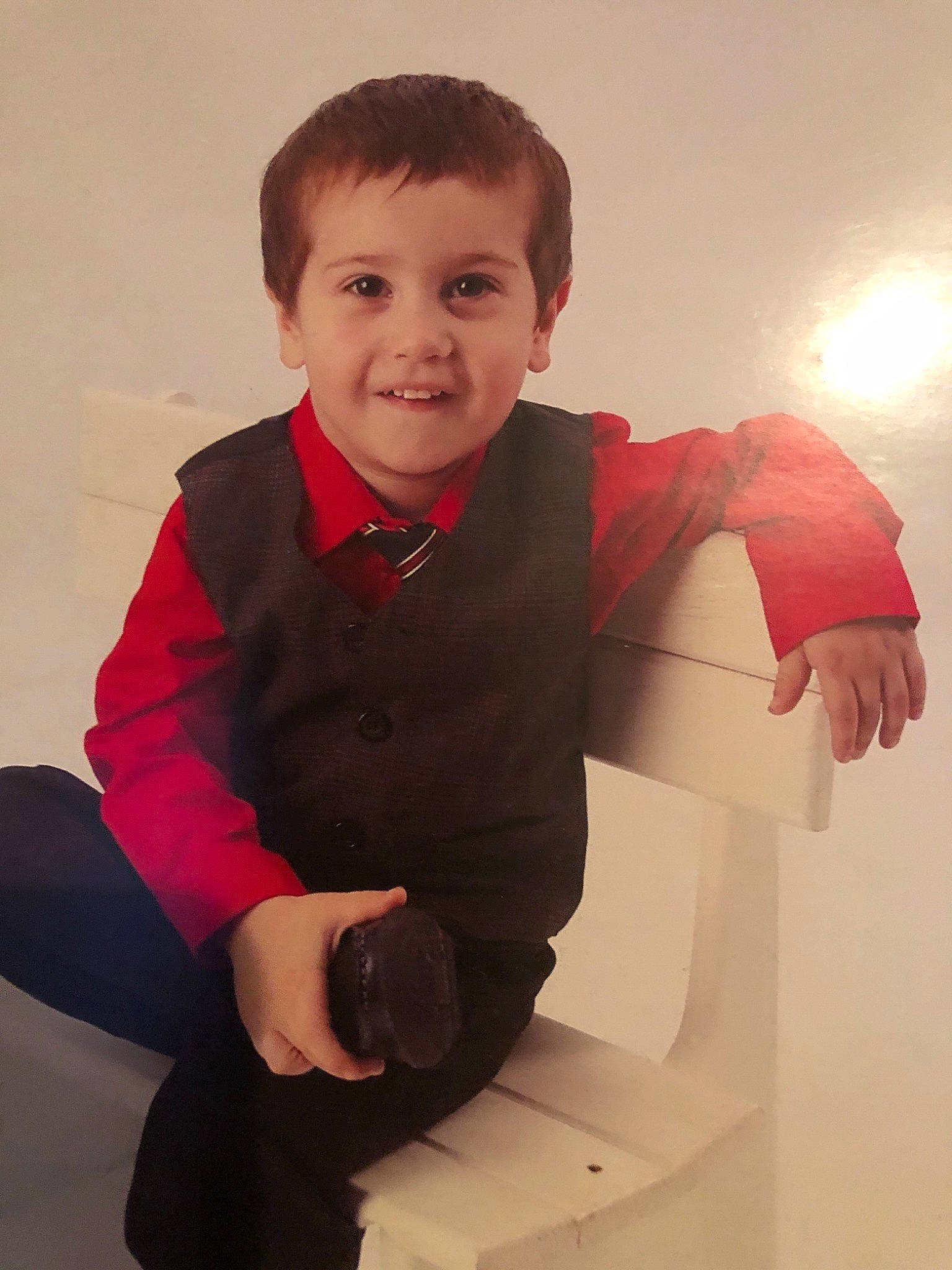Armando is registered to the contest to win money with this photo: arm, child, finger, formal_wear, fun, gesture, joy, outerwear, person, play, sleeve, smile, standing, thumb, toddler