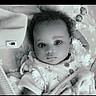baby, infant, face, curly_hair, blanket, plush_toy, star_pattern, bedding, clothing, buttoned_shirt, lying_down, portrait, monochrome, cute, child, soft_texture, indoors, calm, closeup, young