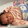 baby, infant, blanket, crib, sleepwear, pink_onesie, elephant_pattern, curly_hair, drool, resting, mesh_crib_side, cute, child, sleepy, indoors, soft_texture, comfort, toddler, smiling, face