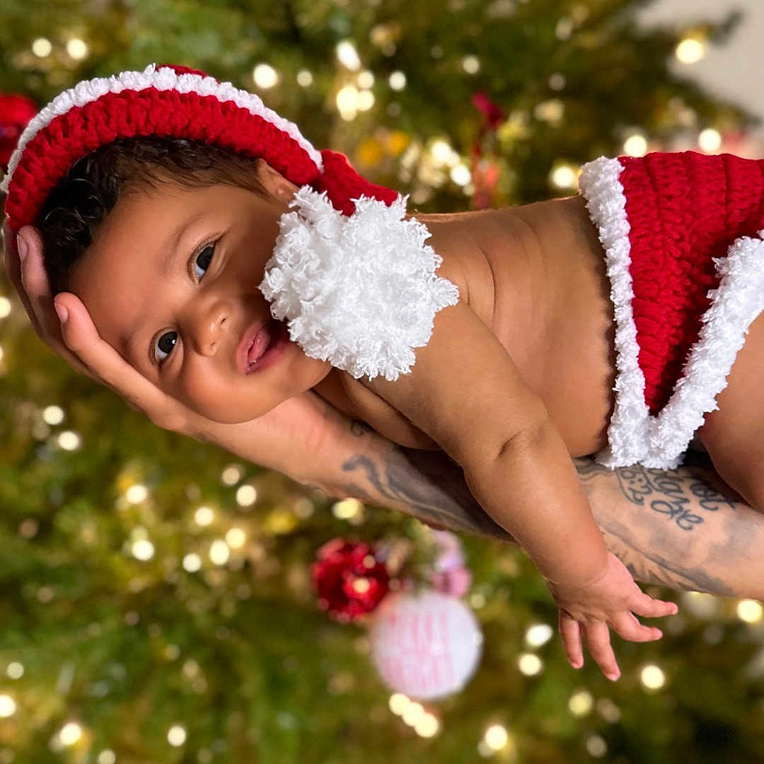 Storii is registered to the contest to win money with this photo: accessories, baby, bodypart, bonnet, cap, clothing, face, finger, hand, happy, hat, head, person, photography, plant, portrait, skin, smile, tattoo, tree