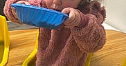 Navaya joined the competition — help win amazing prizes! baby, blue_bowl, child, curly_hair, drinking, eating, face, furniture, hair, indoor, person, pink_sweater, playroom, room, sippy_cup, table, toddler, wall_art, wooden_table, yellow_chair