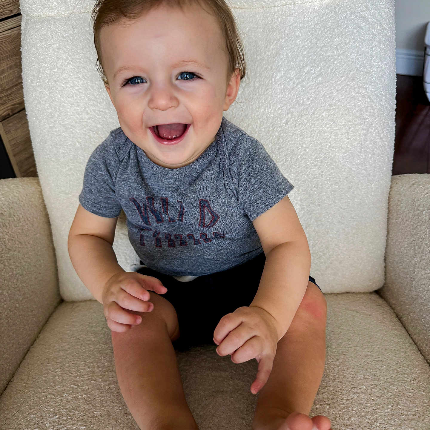 Kane is registered to the contest to win money with this photo: baby, babylaughing, chair, clothing, couch, face, furniture, happy, head, laughing, pants, person, photography, portrait, sitting, smile, t_shirt