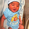 baby, newborn, infant, blue_clothing, hat, smiling, lying_down, blanket, cute, winnie_the_pooh, onesie, soft, skin, face, hand, foot, child, indoors, person, apparel