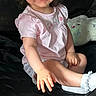 toddler, child, smiling, pink_shirt, pigtails, indoor, plush_toy, carpet, black_background, happy, cute, sitting, reaching_hand, baby, person, portrait, casual, cozy, playful, young_child