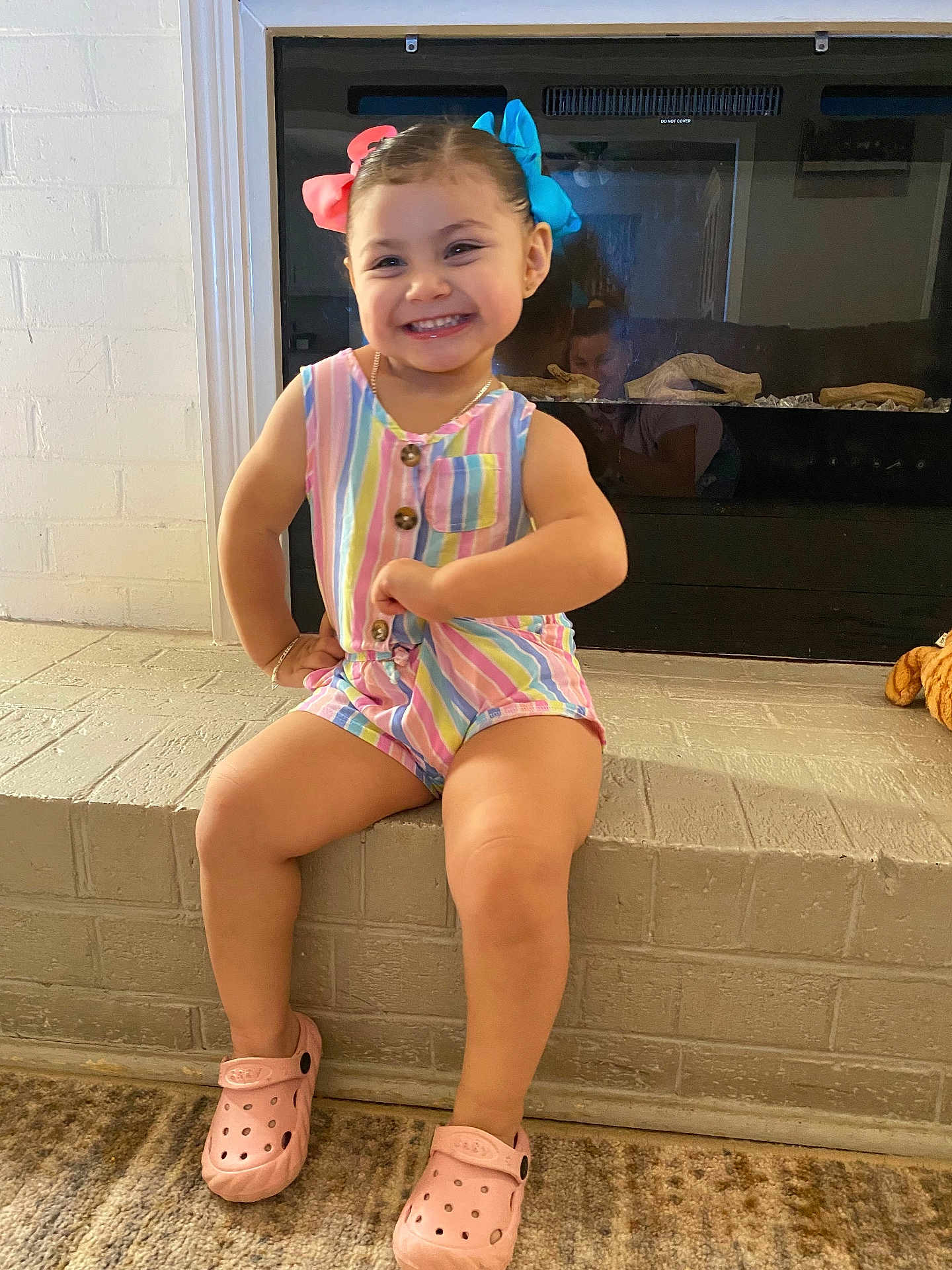 Alexa joined the competition — help win amazing prizes! toddler, child, smiling, colorful_clothing, romper, pink_shoes, hair_bows, indoor, fireplace, brick_hearth, reflection, happy, cute, posing, person, young_child, footwear, playful, casual, family