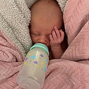 Kali joined the competition — help win amazing prizes! baby, newborn, bottle, blanket, pink_blanket, cream_blanket, sleeping, face, hand, infant, cozy, cute, peaceful, wrapped, nursery, soft_texture, feeding, child, person, indoors