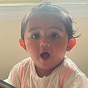 Shreeva joined the competition — help win amazing prizes! baby, child, surprised, indoors, window, natural_light, hair_clip, cute, portrait, expression, pink, white_clothing, face, young_child, person, head, small_hands, curly_hair, sitting, curious