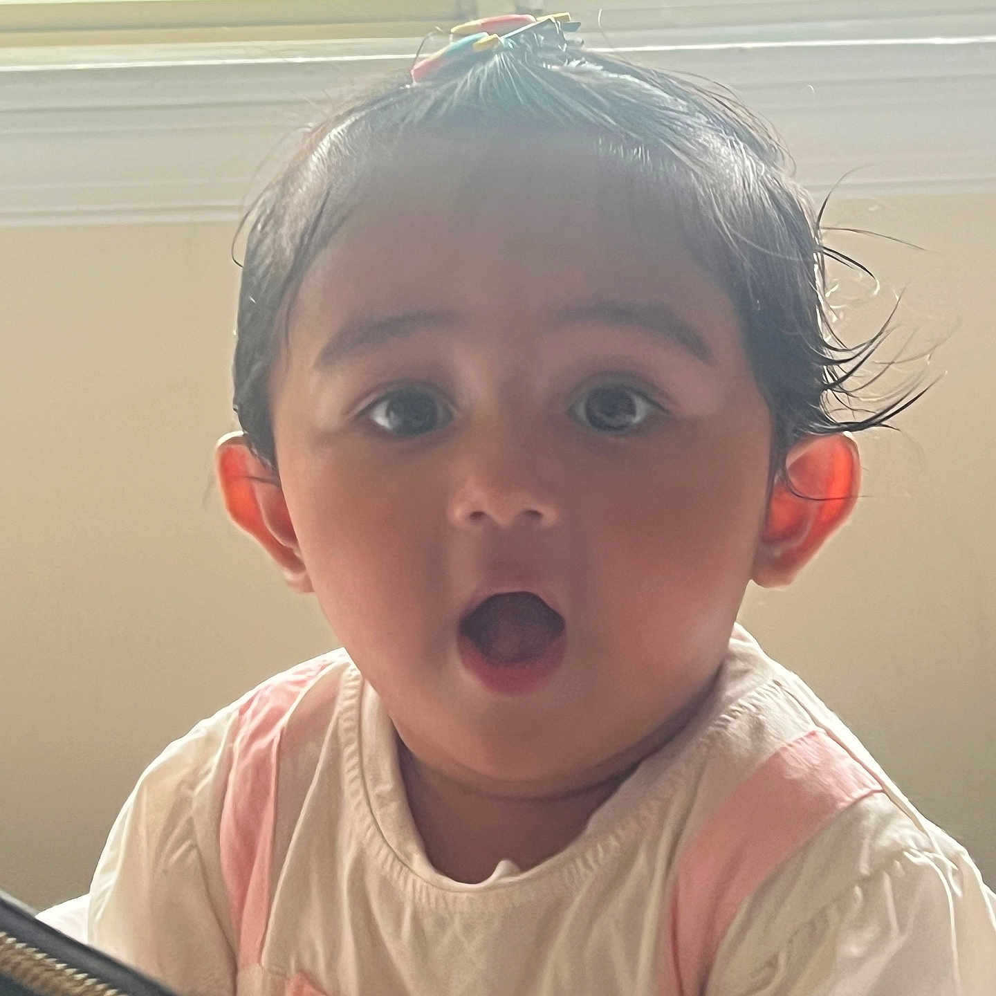 Shreeva joined the competition — help win amazing prizes! baby, child, surprised, indoors, window, natural_light, hair_clip, cute, portrait, expression, pink, white_clothing, face, young_child, person, head, small_hands, curly_hair, sitting, curious