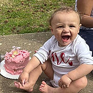 Kaelee is registered to the contest to win money with this photo: baby, child, cake, pink_cake, outdoor, grass, concrete, happy, messy, frosting, foot, hand, sitting, celebration, smiling, cute, person, food, birthday, fun