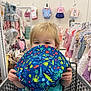 toddler, child, shopping_cart, hat, blue, clothing_store, baby_clothes, rack, toy, cute, playful, indoor, retail, person, blonde_hair, holding, pattern, starfish, octopus, crab