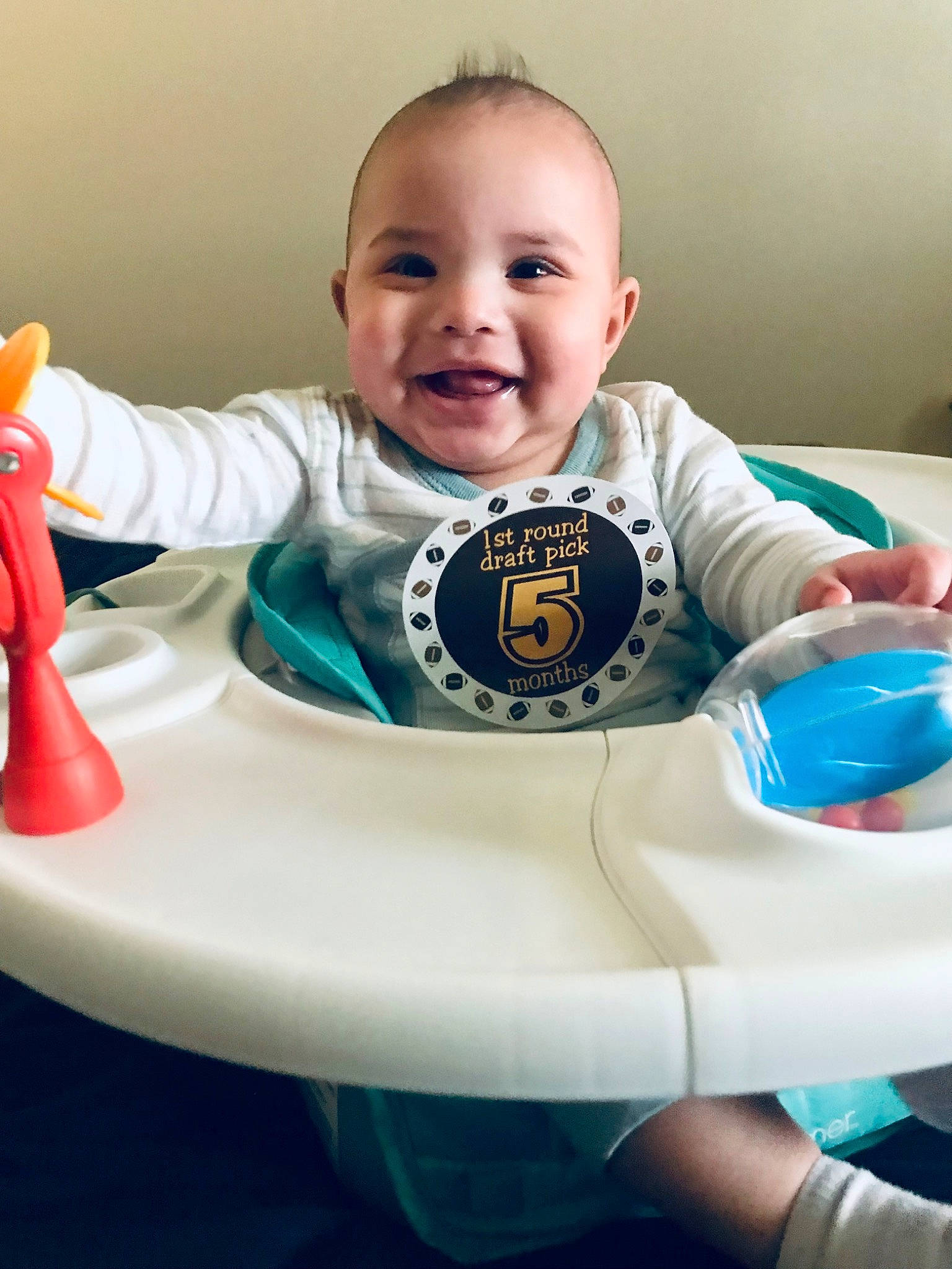 Armon is registered to the contest to win money with this photo: baby, baby_playing_with_toys, baby_products, baby_toddler_clothing, cheek, child, circle, electric_blue, fun, hand, happy, joy, person, sitting, skin, sleeve, smile, steering_wheel, t_shirt, table