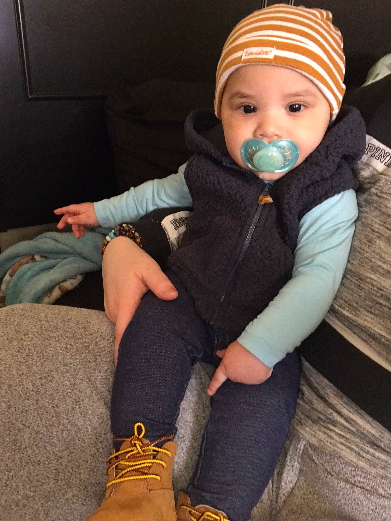 Armon is registered to the contest to win money with this photo: baby, baby_toddler_clothing, cap, comfort, cool, electric_blue, face, finger, headgear, headwear, human_body, human_leg, jeans, knee, knit_cap, leg, person, sitting, sleeve, textile