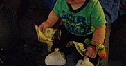 Zack joined the competition — help win amazing prizes! adult, baby, child, clothing, colorful, cozy, dollar_bills, expression, face, footwear, hand, hoodie, indoor, jeans, lap, money, person, sitting, toy, wrist_toy