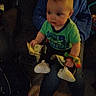 Zack joined the competition — help win amazing prizes! adult, baby, child, clothing, colorful, cozy, dollar_bills, expression, face, footwear, hand, hoodie, indoor, jeans, lap, money, person, sitting, toy, wrist_toy