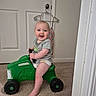 Zack joined the competition — help win amazing prizes! baby, carpet, child, clothing, door, dress, face, foot, green_toy, hand, hanger, happy, head, indoor, person, shorts, smiling, toy, tractor, tshirt