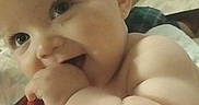 Zack is registered to the contest to win money with this photo: baby, child, infant, hand, chewing, blanket, furniture, couch, indoor, portrait, cute, skin, face, expression, happy, smiling, video, screen_overlay, device, home
