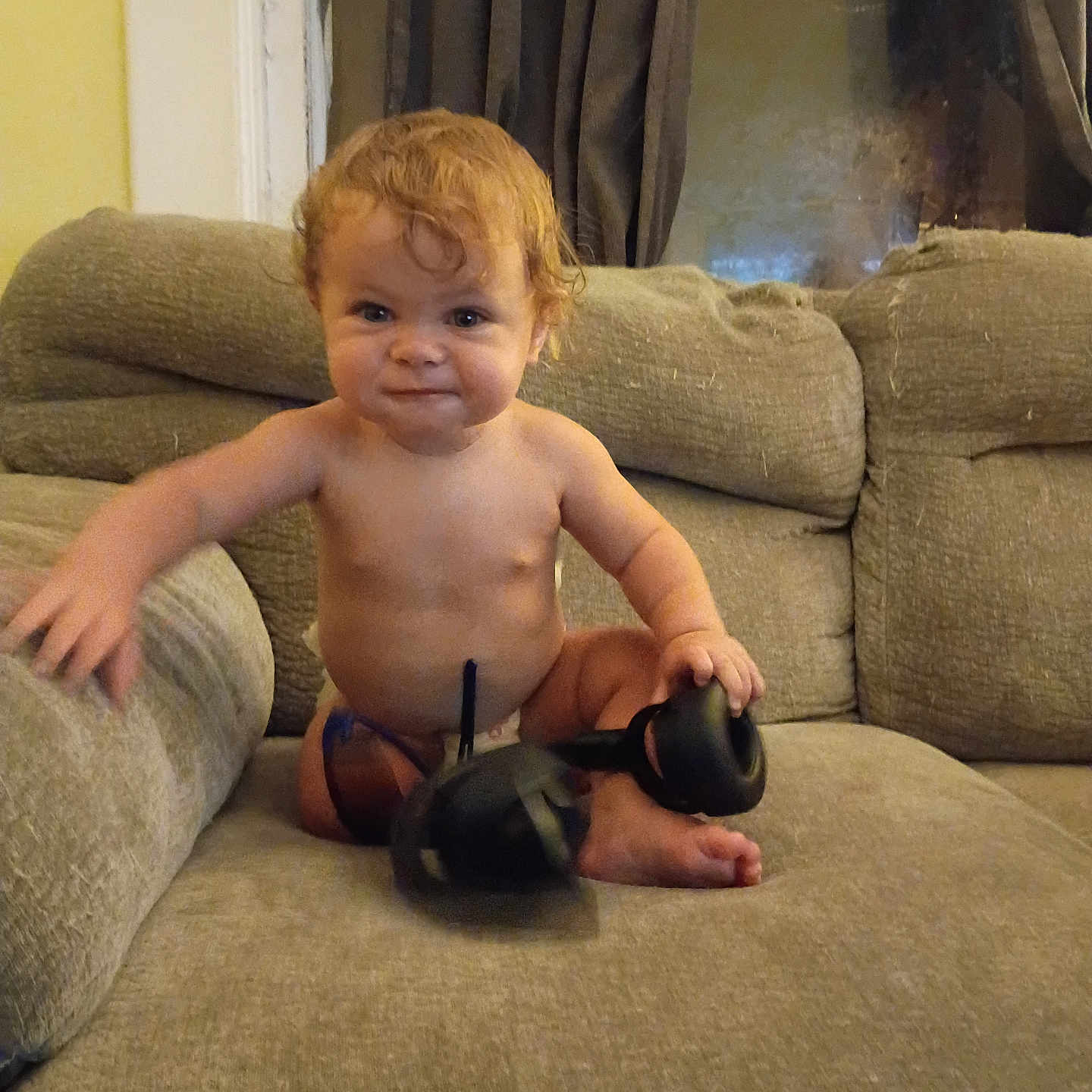 Andrew is registered to the contest to win money with this photo: toddler, child, baby, sitting, couch, sofa, headphones, audio_equipment, indoor, portrait, face, red_hair, smiling, bare_chested, barefoot, living_room, furniture, curtains, home, photography