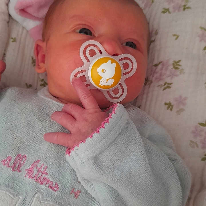 Leelou a rejoint le concours — aidez-le/la à gagner de superbes lots ! baby, blanket, child, cozy_clothing, curious, cute, embroidered_kittens, face, floral_pattern, hand, indoors, infant, lying_down, newborn, pacifier, peaceful, pink_trim, portrait, sleepwear, soft_lighting