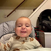 Michael joined the competition — help win amazing prizes! baby, child, smile, high_chair, onesie, indoor, face, happy, infant, person, furniture, staircase, car_seat, baby_gear, table, clothing, cute, portrait, young_child, home