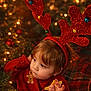 child, christmas, christmas_decor, christmas_tree, cozy, cute, decorations, face, festive, holiday, holiday_season, indoors, lights, person, portrait, red_sweater, reindeer_antlers, seasonal, toddler, warm_lighting