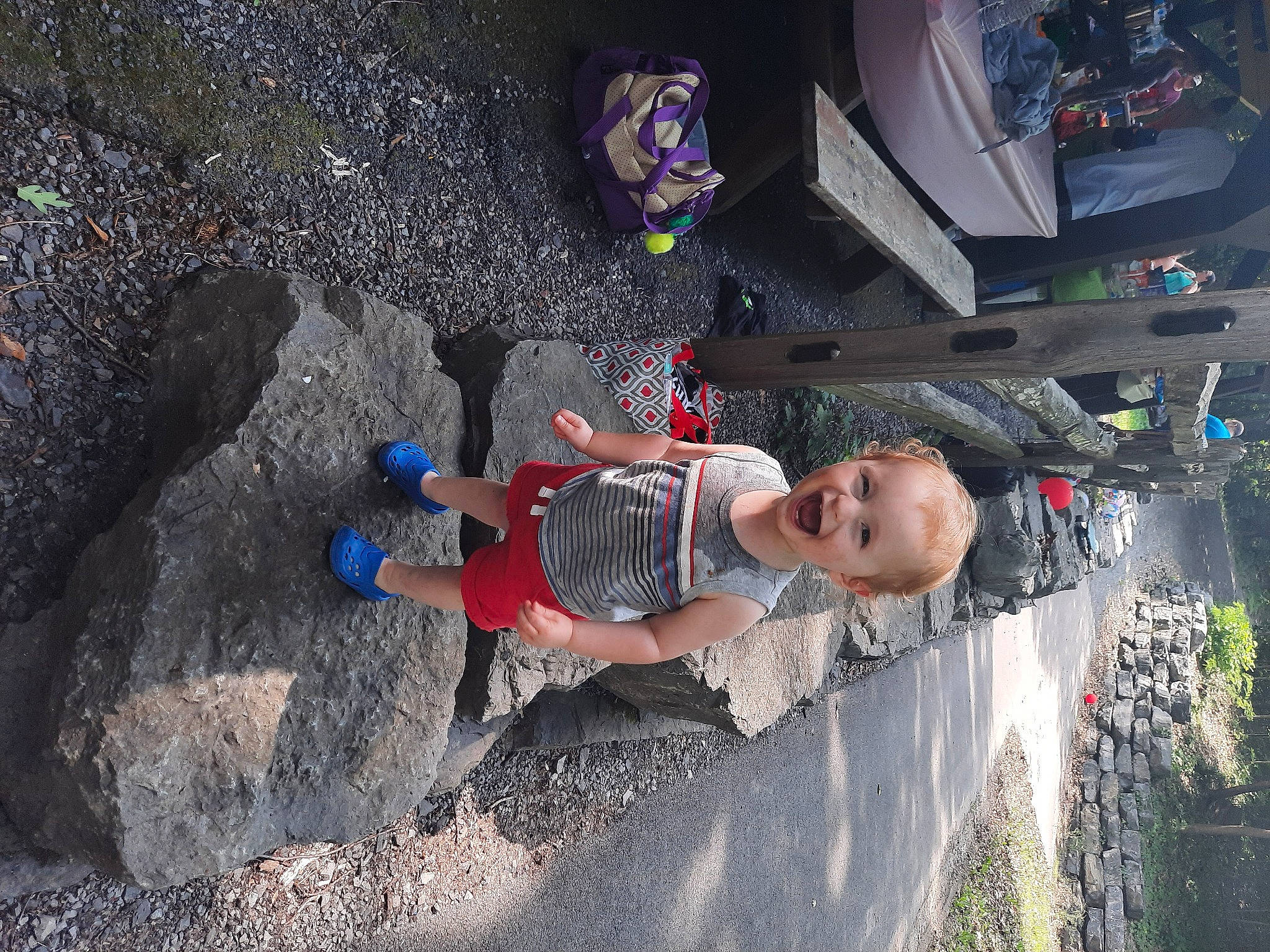 Charles is registered to the contest to win money with this photo: adventure, auto_part, automotive_exterior, automotive_tire, bumper, child, city, concrete, fun, leisure, motor_vehicle, pedestrian, person, plant, recreation, rock, shadow, soil, t_shirt, toddler