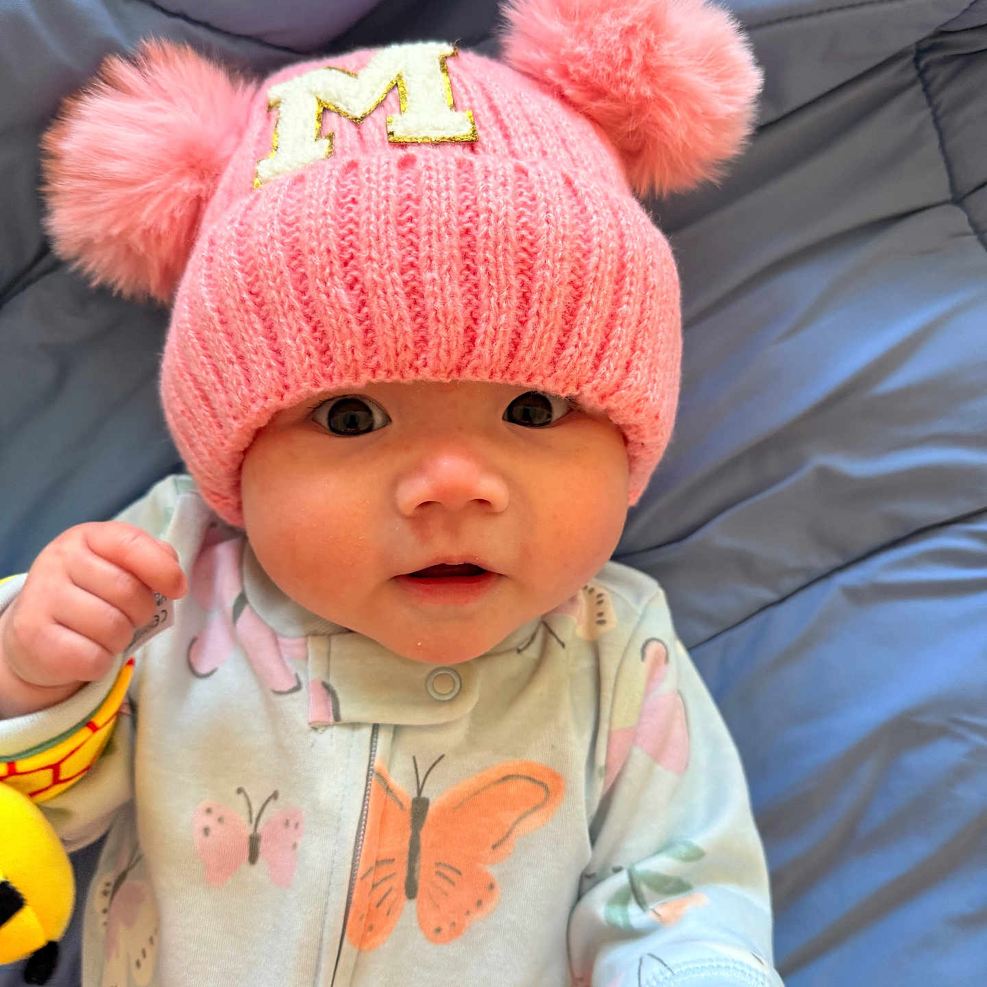 Myla joined the competition — help win amazing prizes! adorable, baby, blue_blanket, butterfly_pattern, child, closeup, cute, eyes, face, hands, hat, indoors, infant, onesie, pink_hat, pom_poms, portrait, sleepwear, smiling, soft_texture