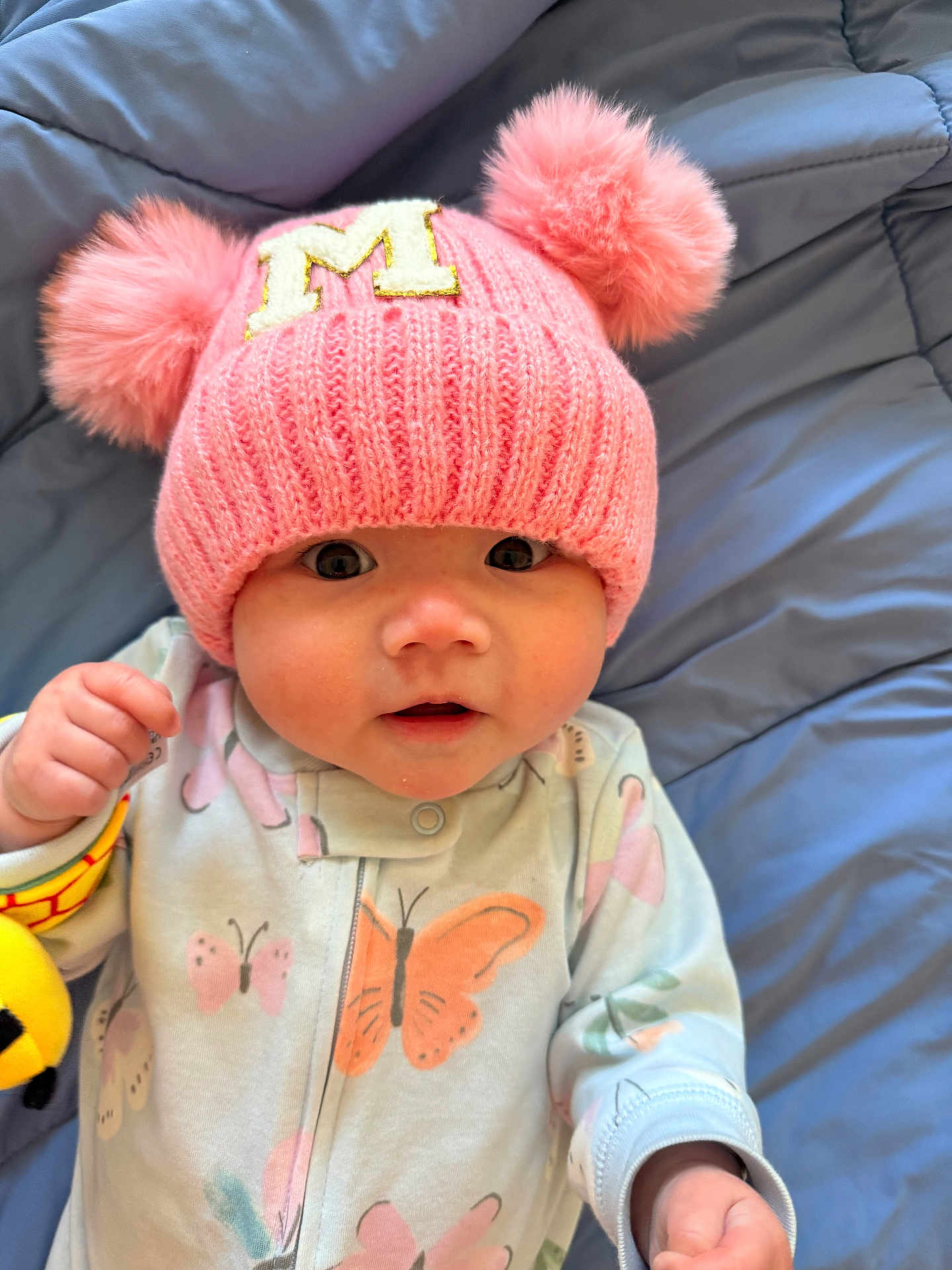 Myla joined the competition — help win amazing prizes! baby, infant, hat, pink_hat, pom_poms, onesie, butterfly_pattern, blue_blanket, soft_texture, cute, face, eyes, hands, sleepwear, child, portrait, indoors, closeup, adorable, smiling