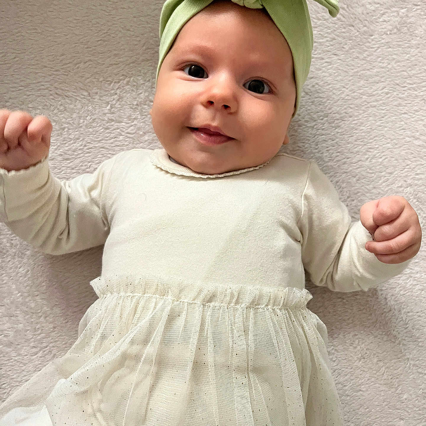 Tanya a rejoint le concours — aidez-le/la à gagner de superbes lots ! apparel, baby, blanket, bow, child, closeup, cream_clothing, cute, face, hands, happy, headband, human, indoors, infant, lying_down, portrait, smile, soft_texture, tulle_skirt