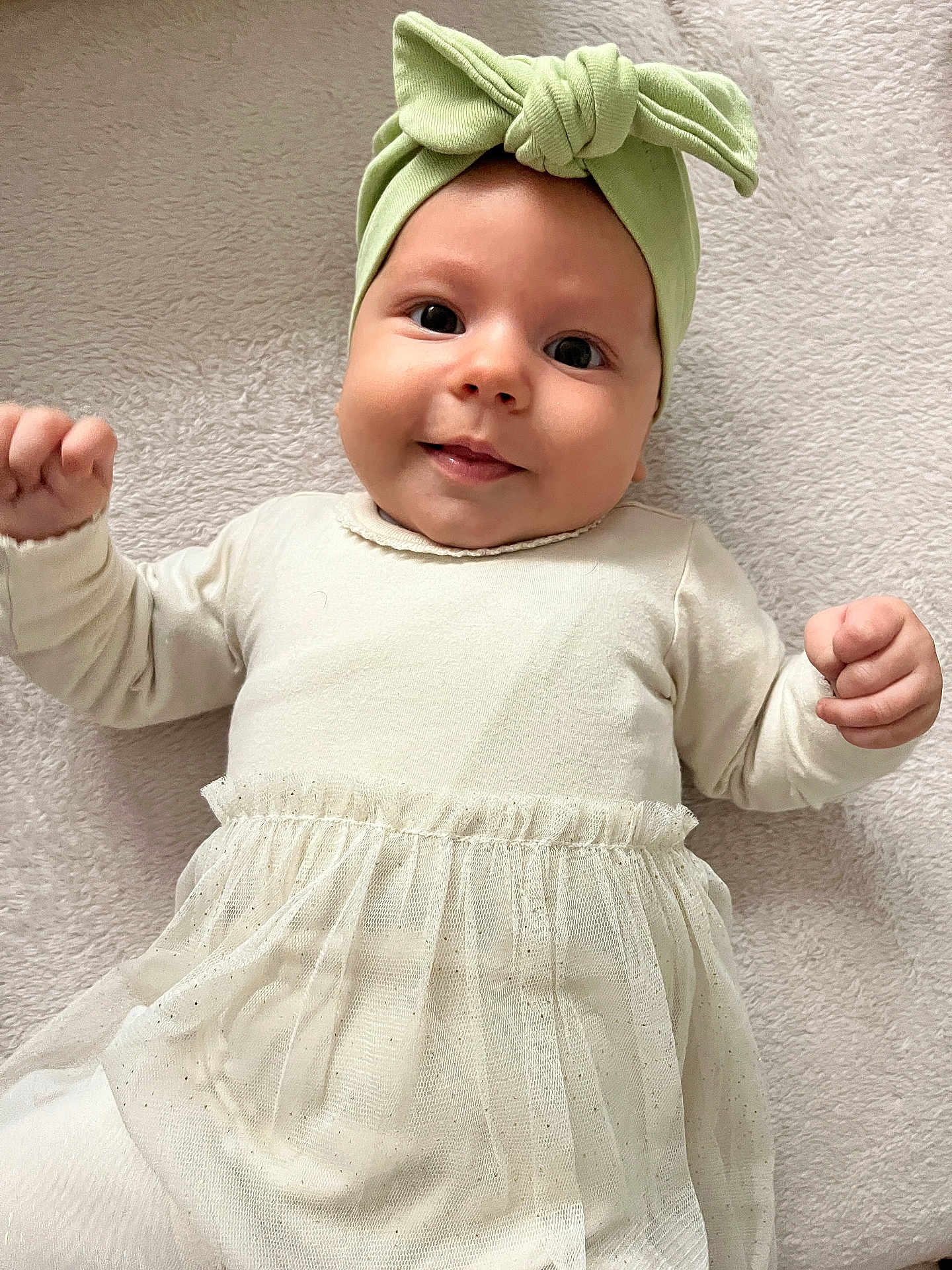 Tanya a rejoint le concours — aidez-le/la à gagner de superbes lots ! baby, infant, smile, headband, bow, tulle_skirt, cream_clothing, lying_down, blanket, soft_texture, cute, happy, child, portrait, closeup, indoors, human, face, hands, apparel